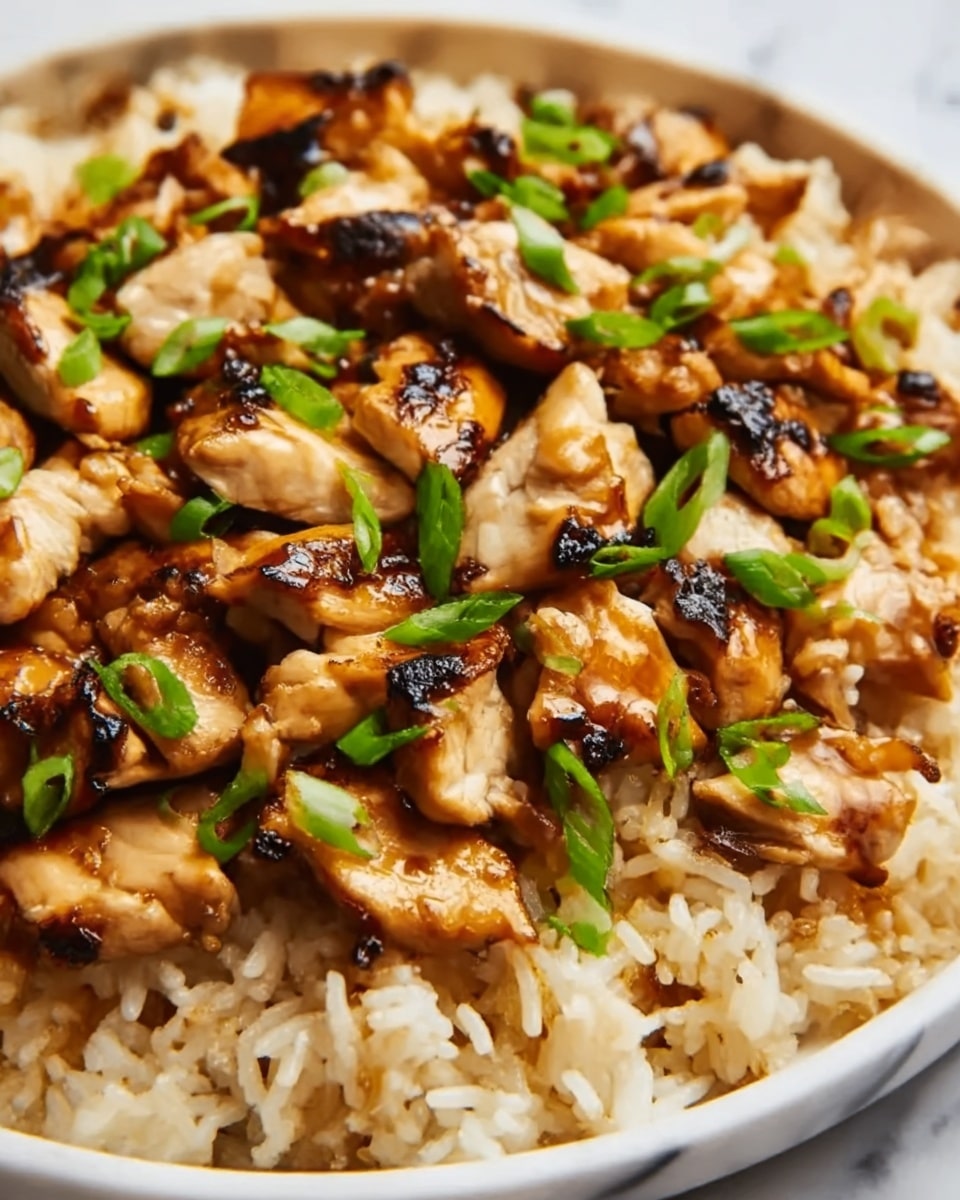 A close-up of a dish with three layers: the bottom layer is soft, light brown cooked rice with a slightly glossy texture; the middle layer consists of grilled chicken pieces, golden brown with some darker char marks, looking juicy and tender; on the top are small green sliced scallions scattered over the chicken, adding a fresh color. The dish is on a white plate that sits on a white marbled surface. Photo taken with an iphone --ar 4:5 --v 7