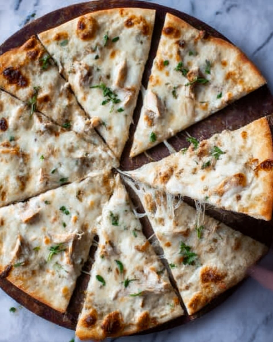 A white marbled surface holds a round pizza cut into eight uneven slices. The pizza has a thin crust with a slightly browned edge. The top layer is melted white cheese with some golden brown spots, scattered with small pieces of cooked chicken. Fresh green herbs are sprinkled lightly across the pizza. A woman's hand is reaching towards one of the slices, showing the stringy texture of the melted cheese. The pizza is placed on a simple round board with a dark finish. photo taken with an iphone --ar 4:5 --v 7