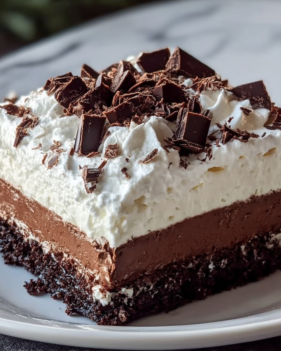 A close-up of a square layered chocolate dessert on a white plate, placed on a white marbled surface. The bottom layer is dark, dense chocolate cake with a crumbly texture. Above that is a thick, smooth layer of white cream filling. The third layer is a thinner, slightly grainy chocolate filling. The topmost layer is a generous swirl of fluffy white whipped cream, decorated with irregular chunks and shavings of dark chocolate scattered unevenly on top. Photo taken with an iphone --ar 4:5 --v 7