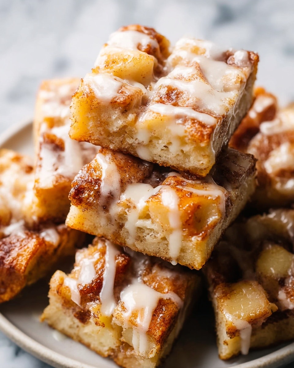 A close-up view of several square cinnamon roll pieces stacked on a round white plate, each piece showing a thick base layer of golden-brown baked dough topped with a chunky layer of cinnamon-spiced dough pieces. The top is richly covered with a glossy, white glaze drizzled unevenly that seeps into the cracks between the cinnamon chunks, creating a shiny and slightly sticky texture. The rough, warm brown cinnamon layers contrast with the smooth creamy glaze, and the whole plate sits on a white marbled surface. photo taken with an iphone --ar 4:5 --v 7